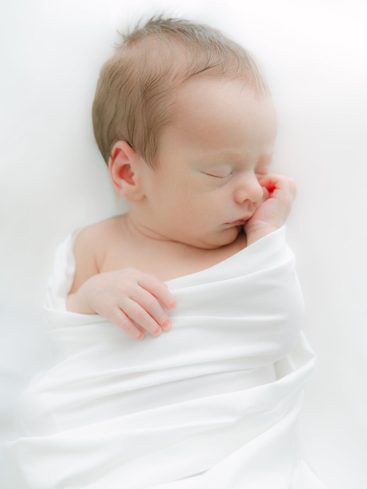 Swaddled sleeping baby by raleigh newborn photos 