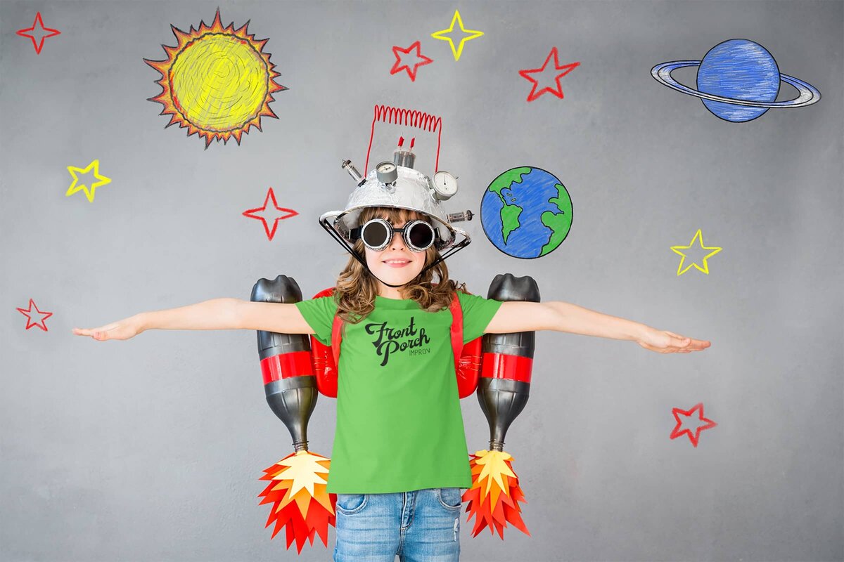 A young girl pretending to be an astronaut wearing a green Front Porch Improv logo t-shirt