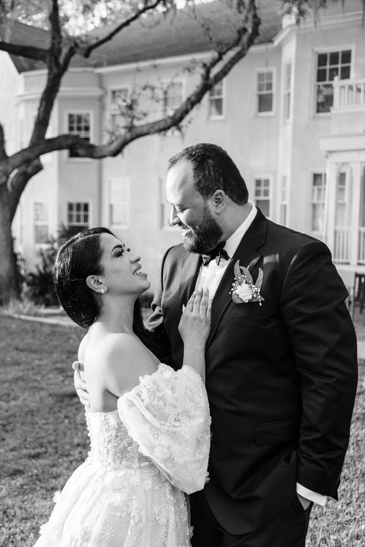 Black and White photo of bride and groom hugging and looking at each other smiling