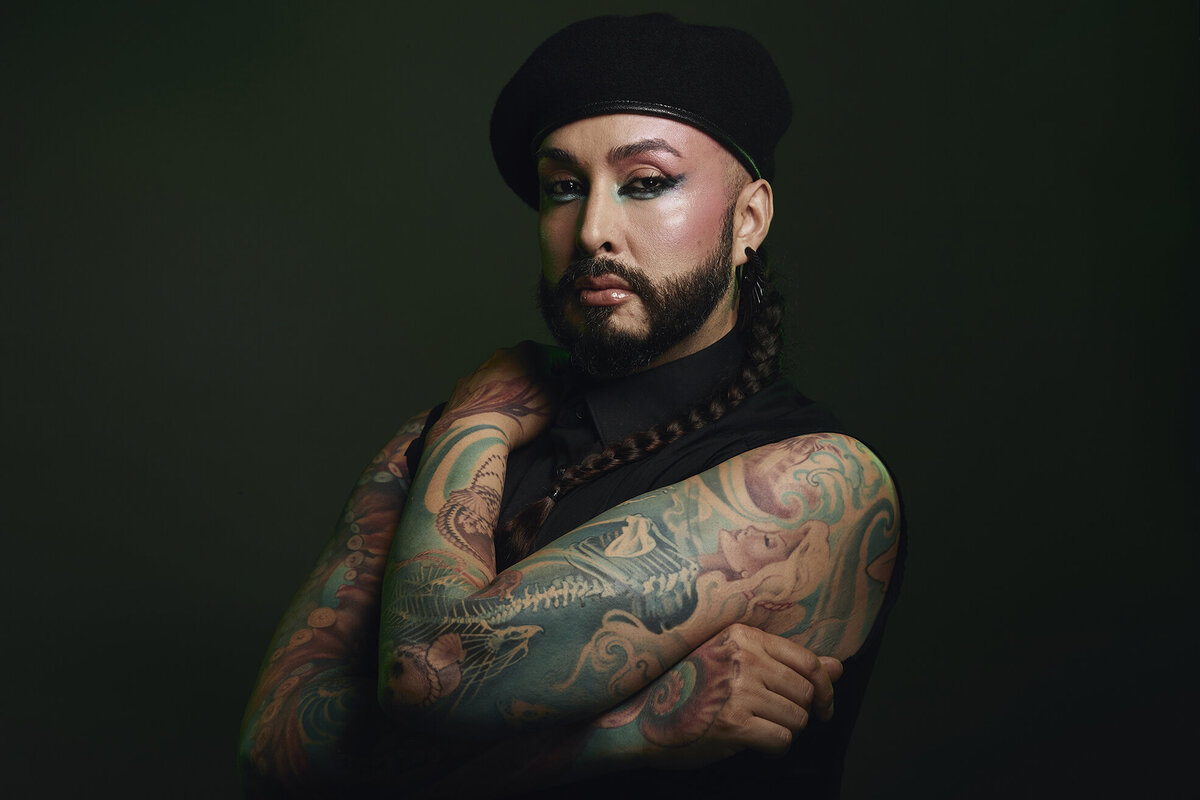 Bold and expressive portrait of Nick Lujan with tattoos and a focused gaze, photographed by Ylva Erevall.