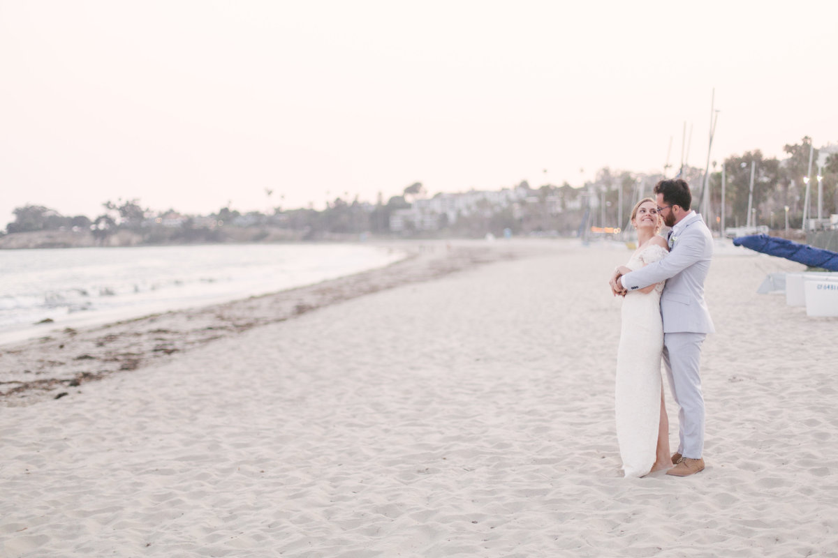 Bride and groom stand along coastline at Santa Barbara Yacht Club wedding