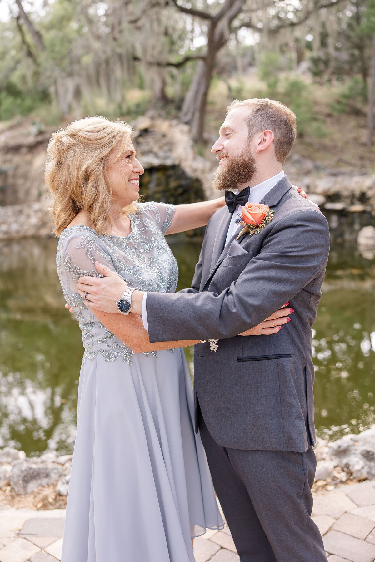 groom and mother of groom embrace and smile  after Hayes Hollow at Hidden Falls wedding in Spring Branch Texas