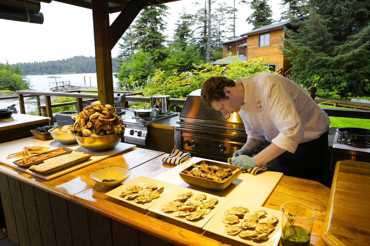 Chef preparing food at a luxury outdoor cabin lodge