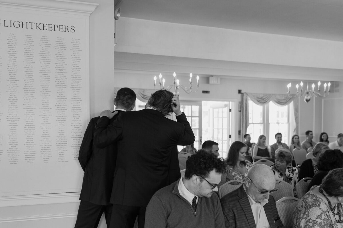 The groom and his brother peek around the corner—documentary wedding photographer.