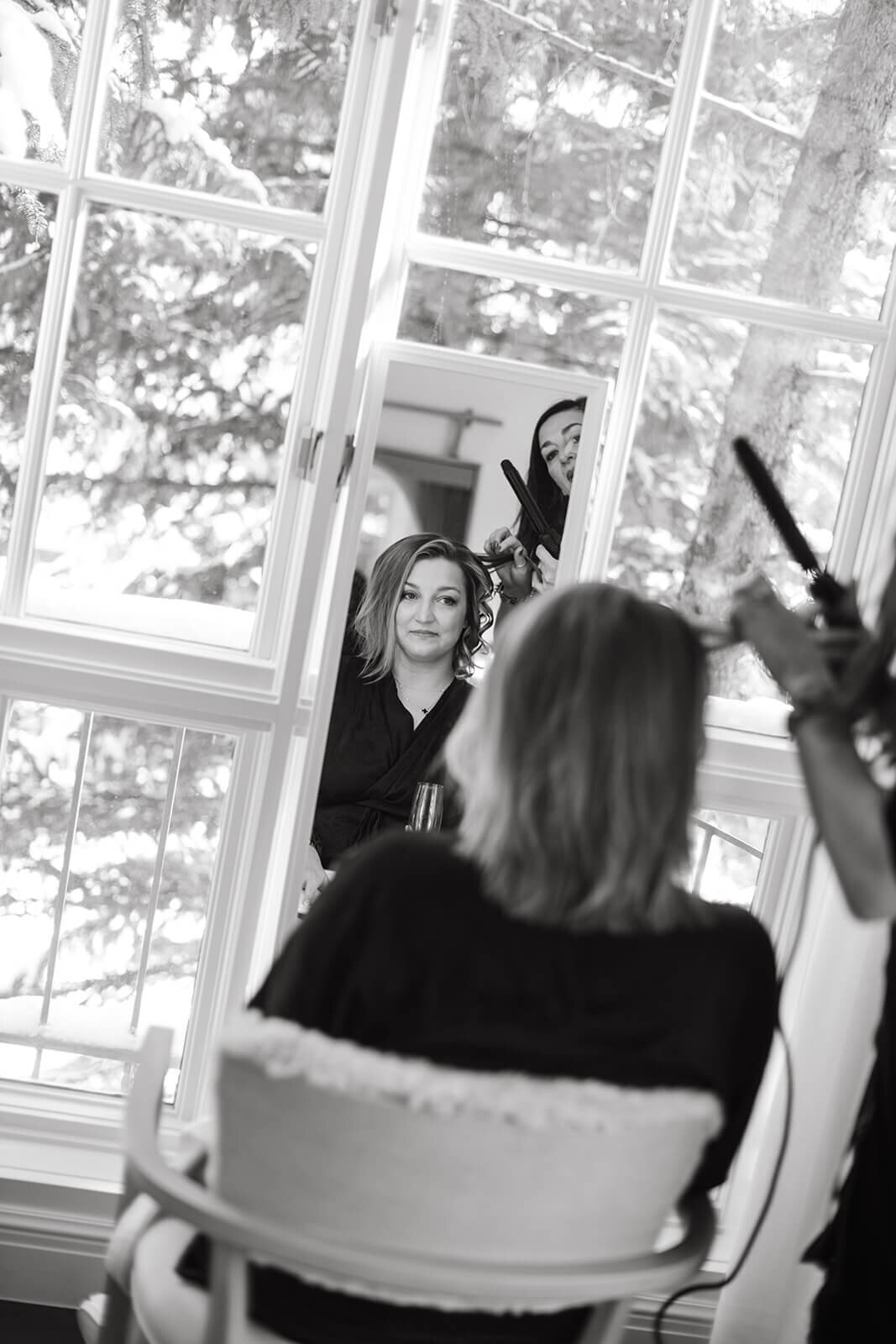 Bride getting her hair styled at St. Regis Aspen, surrounded by natural light and elegant details in a refined suite.