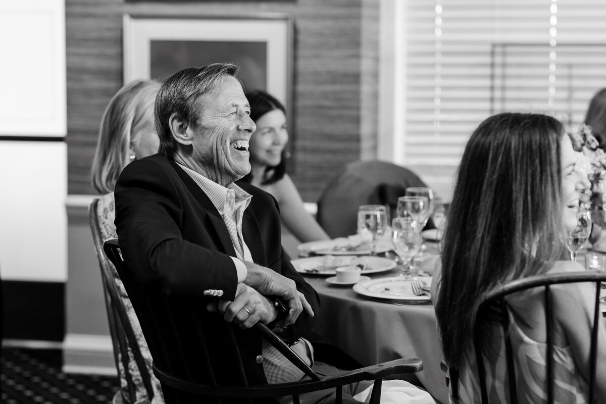 guest laughing during speeches at  rehearsal dinner 