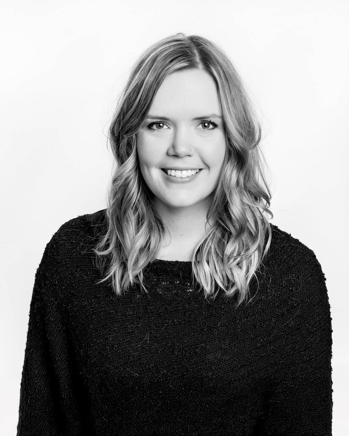 Black-and-white-headshot-of-woman-with-blonde-hair-and-black-sweater
