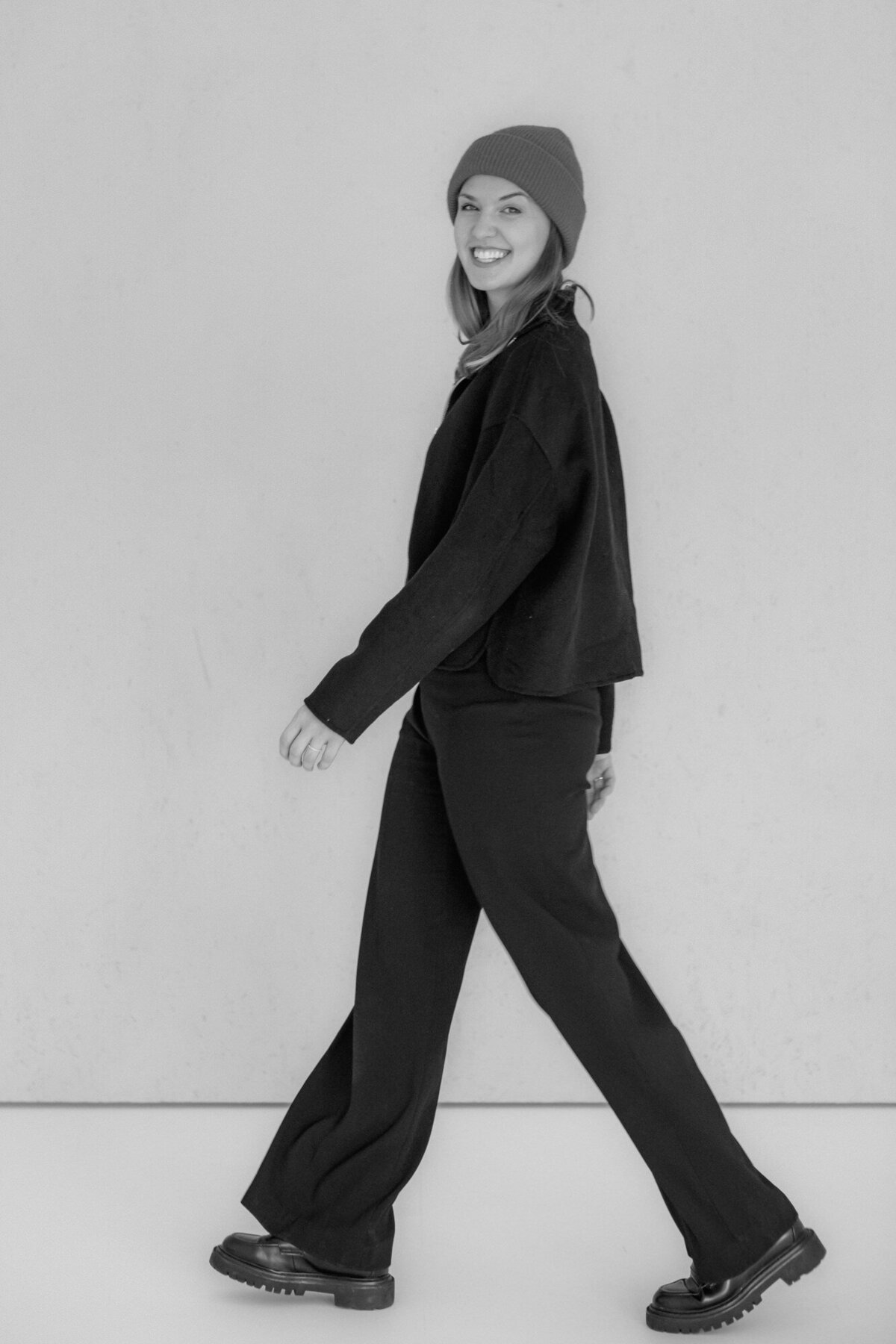 Portrait Photography of a woman smiling at the camera while walking sidewards.