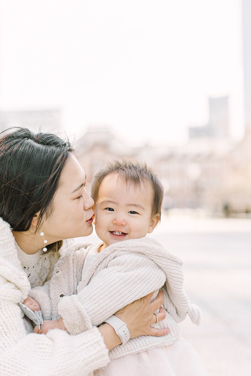 ママから頬にキスをしてもらっている、可愛い女の子のバースデーフォト。東京駅前でYukika Ishikawa Photographyが撮影。
