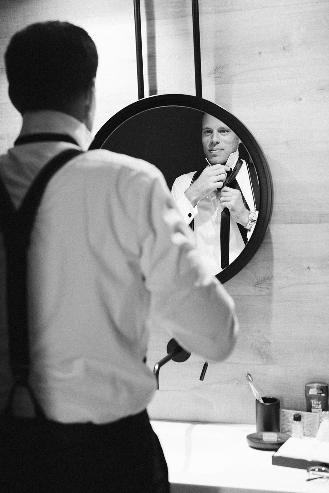 The groom getting ready and fixing his tie