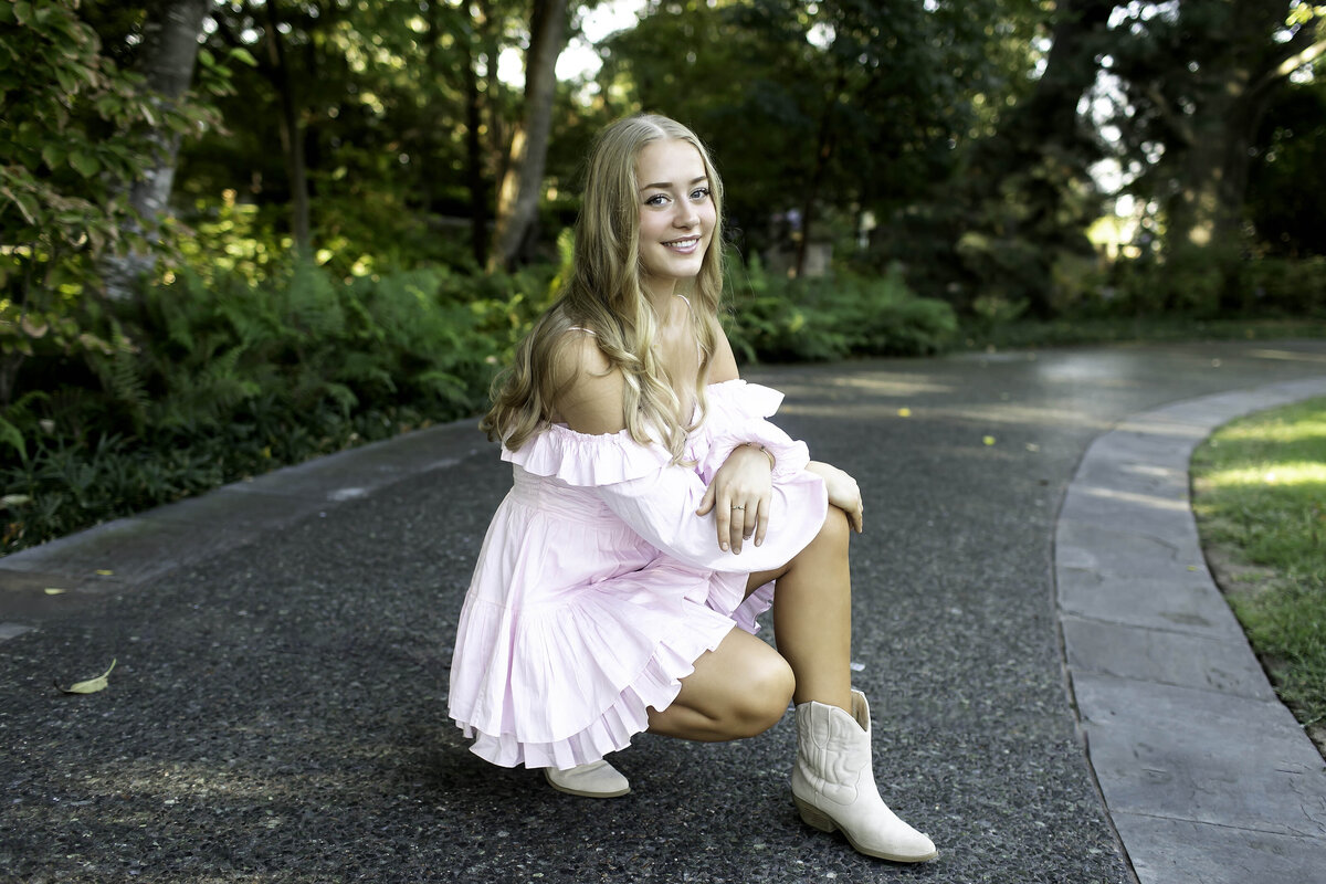A high school senior strikes a fun, playful pose with their friends during the photoshoot.