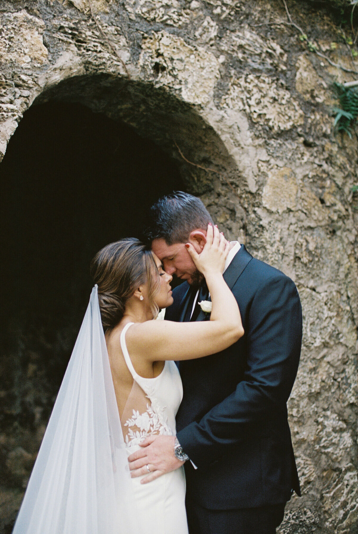 stone-archway-newlyweds-embrace-6GJ-W