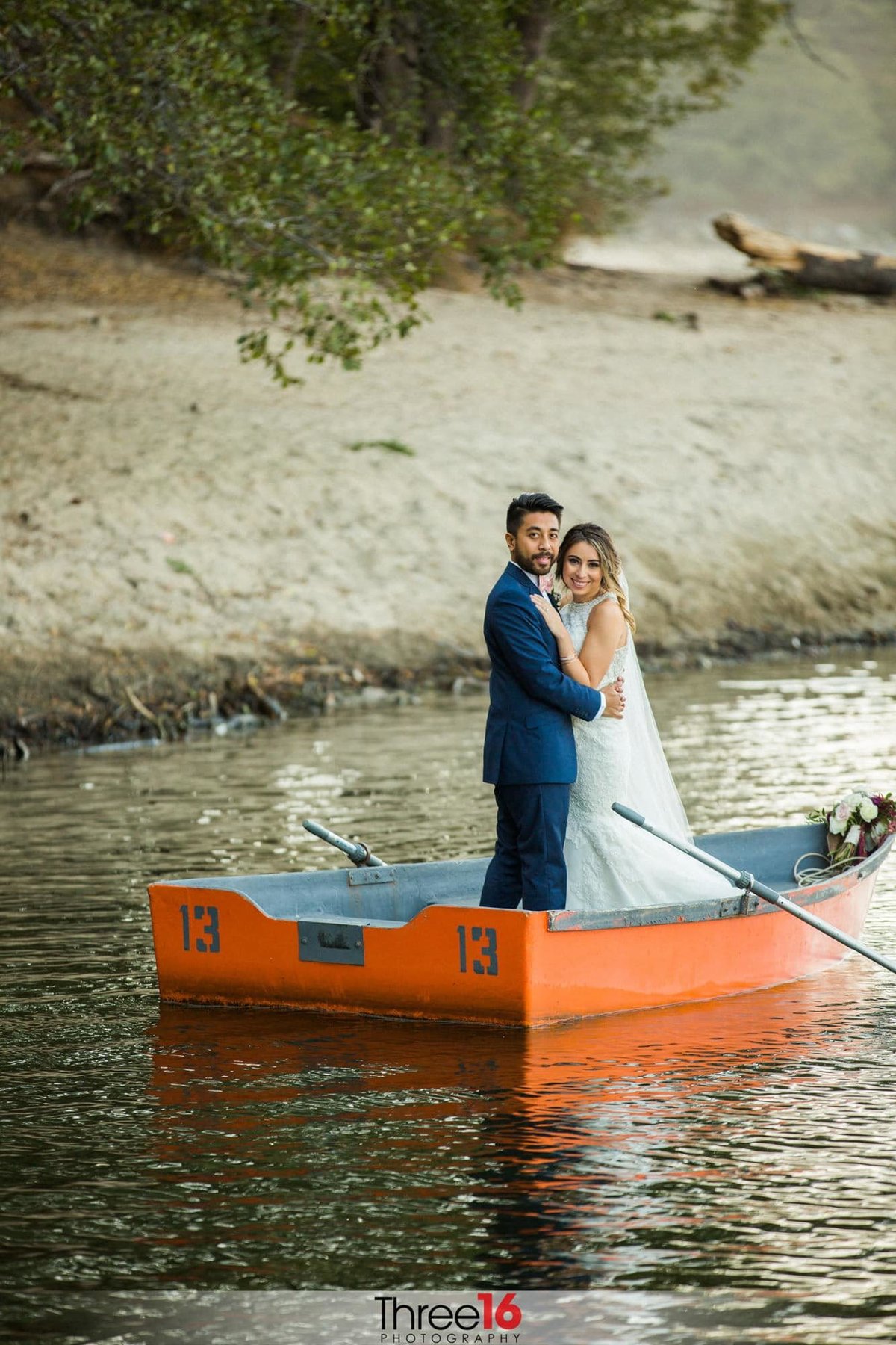 Bride and Groom pose on a row boat