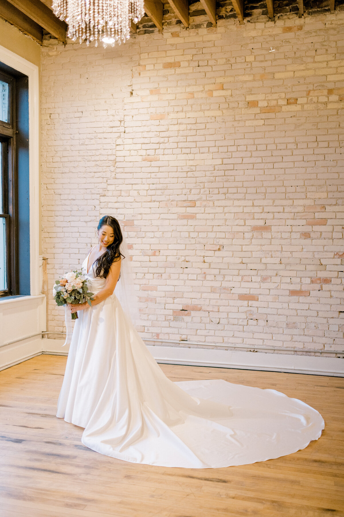 bride standing looking behind at her dress
