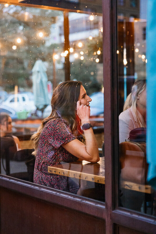 Woman sits at restaurant table.