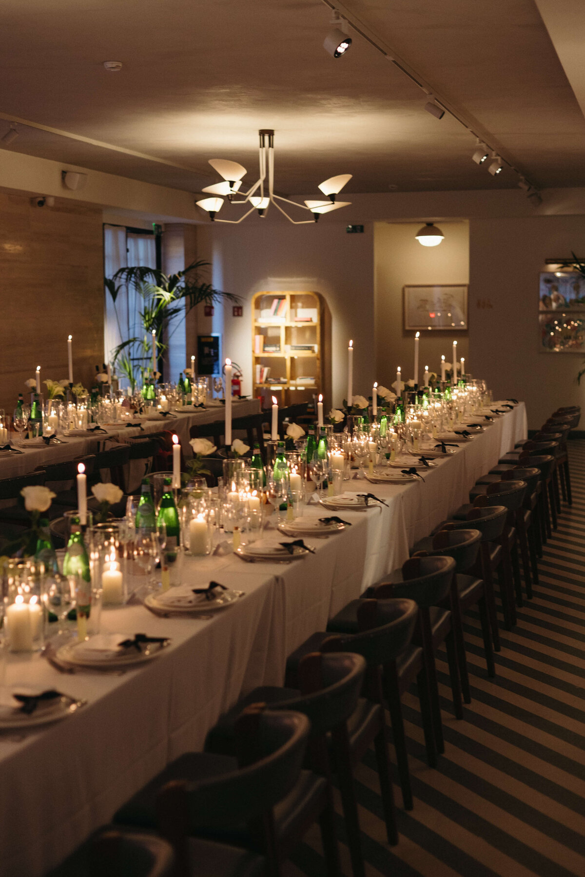 Long reception table with white linens, candles, and modern decor at Soho House Rome

