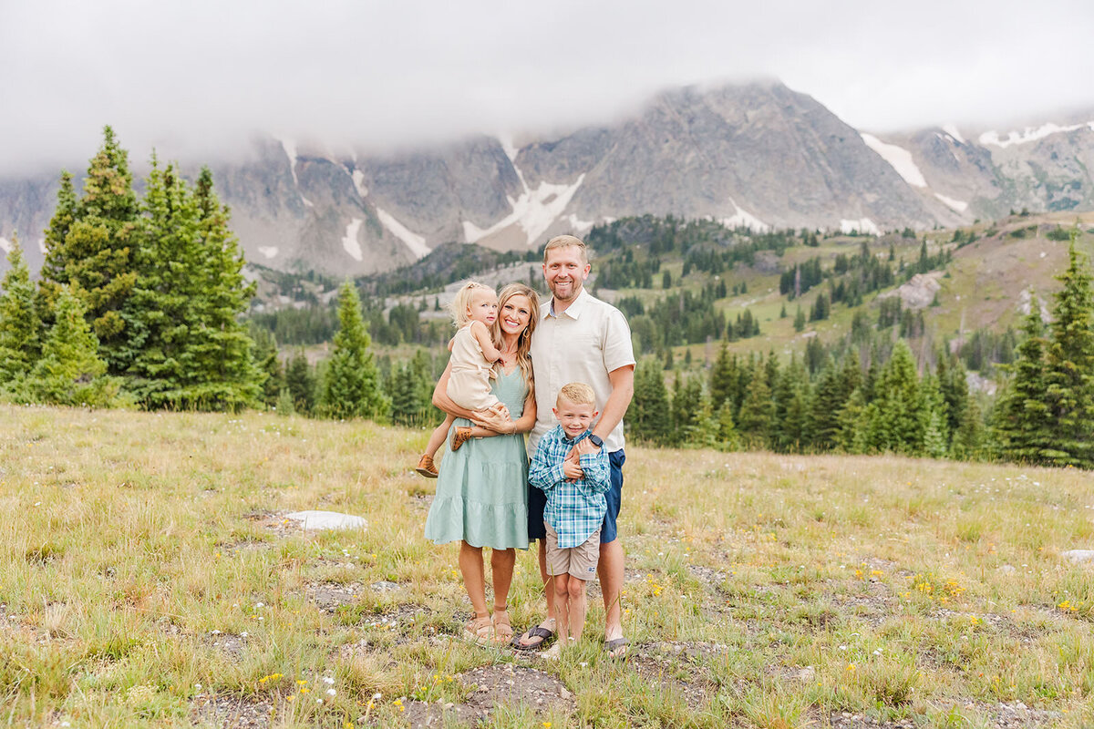 Family of 4 posing together during their summer family session in the Snowy Range Mountains near Laramie, Wyoming.