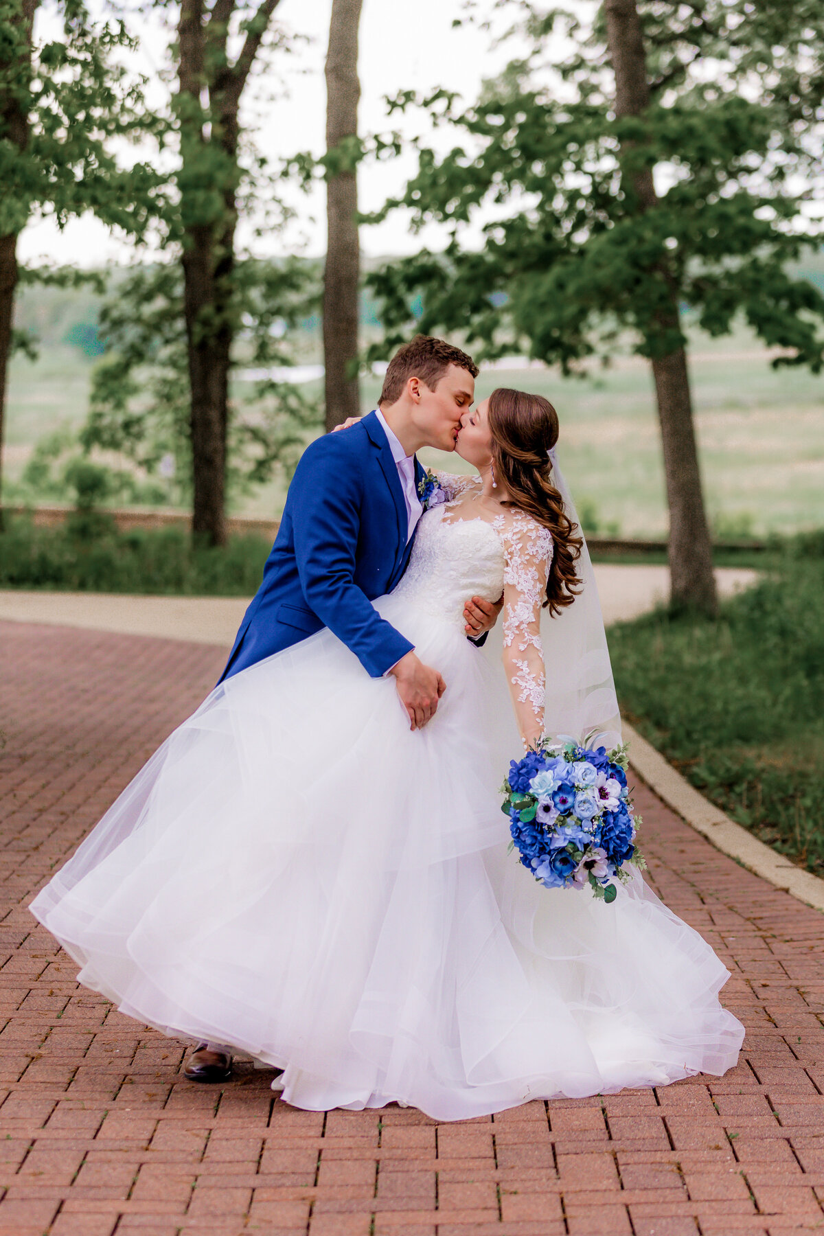 A groom dips his bride while they share a kiss.