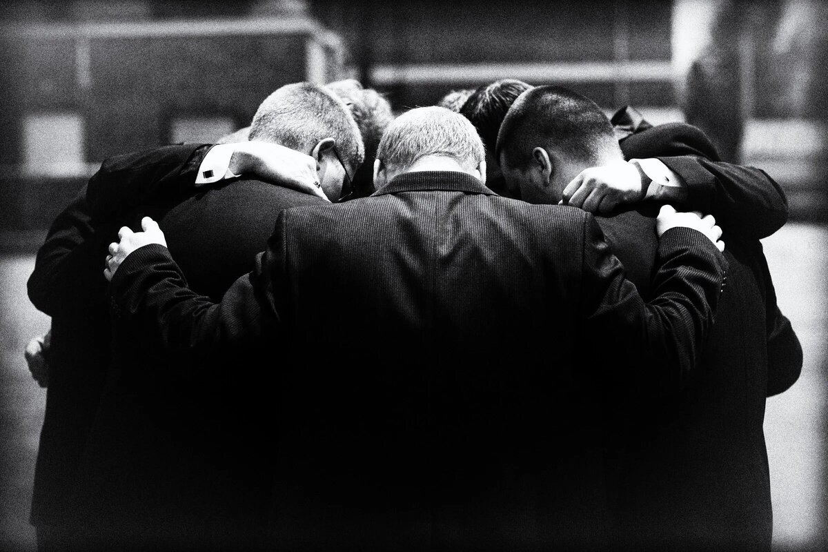 A group of men huddled in a circle together