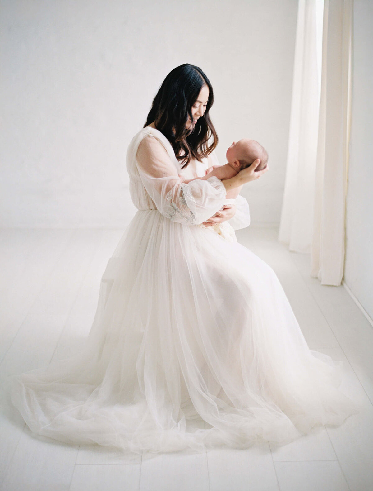 Mother holding newborn at Bay Area newborn photographer studio session.