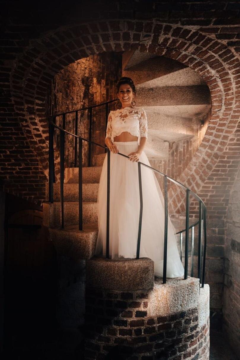 A woman in a white wedding dress standing on a set of stairs