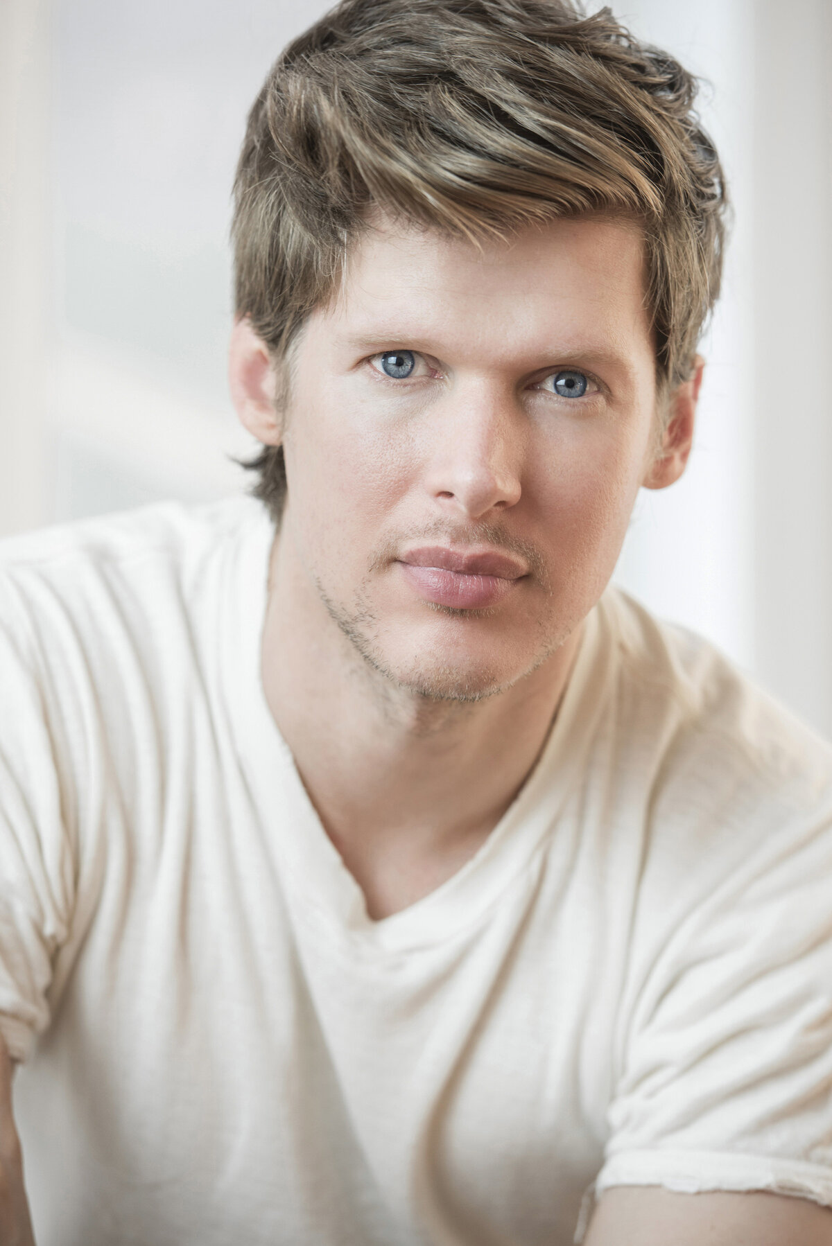 A man in a white tshirt with a serious face