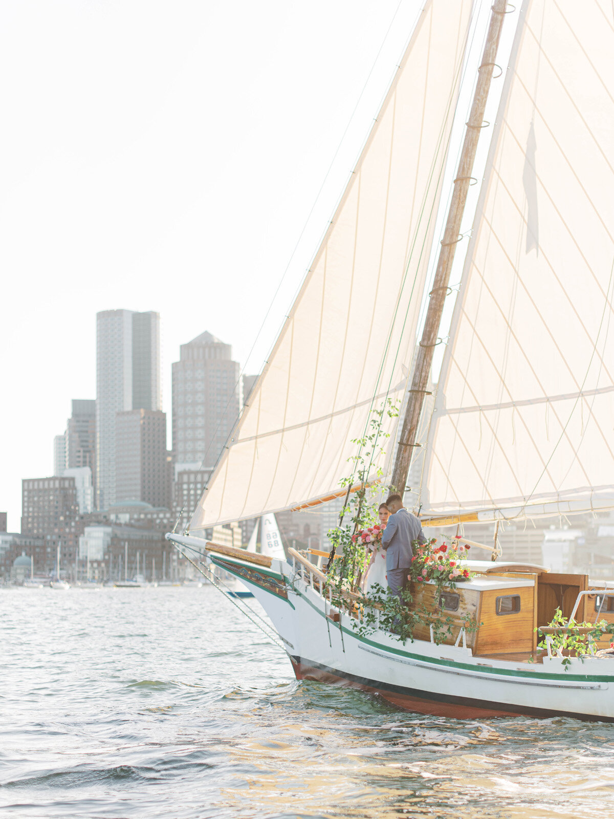 Kate-Murtaugh-Events-elopement-wedding-planner-Boston-Harbor-sailing-sail-boat-yacht-greenery-floral-installation-couple-bride-groom-water-skyline-view