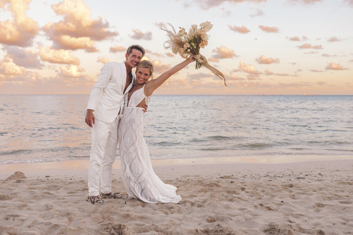 Bride and groom celebrating on beach at viceroy riviera maya wedding