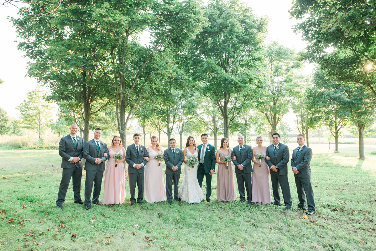 Wedding party standing side by side for formal wedding photos at a private residence in the trees.
