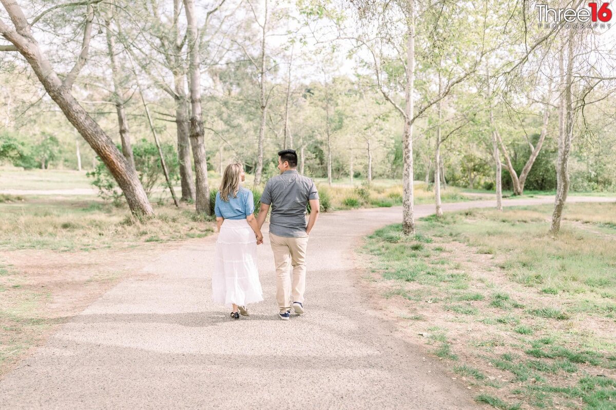 Engaged couple take a stroll through Talbert Regional Park in Costa Mesa
