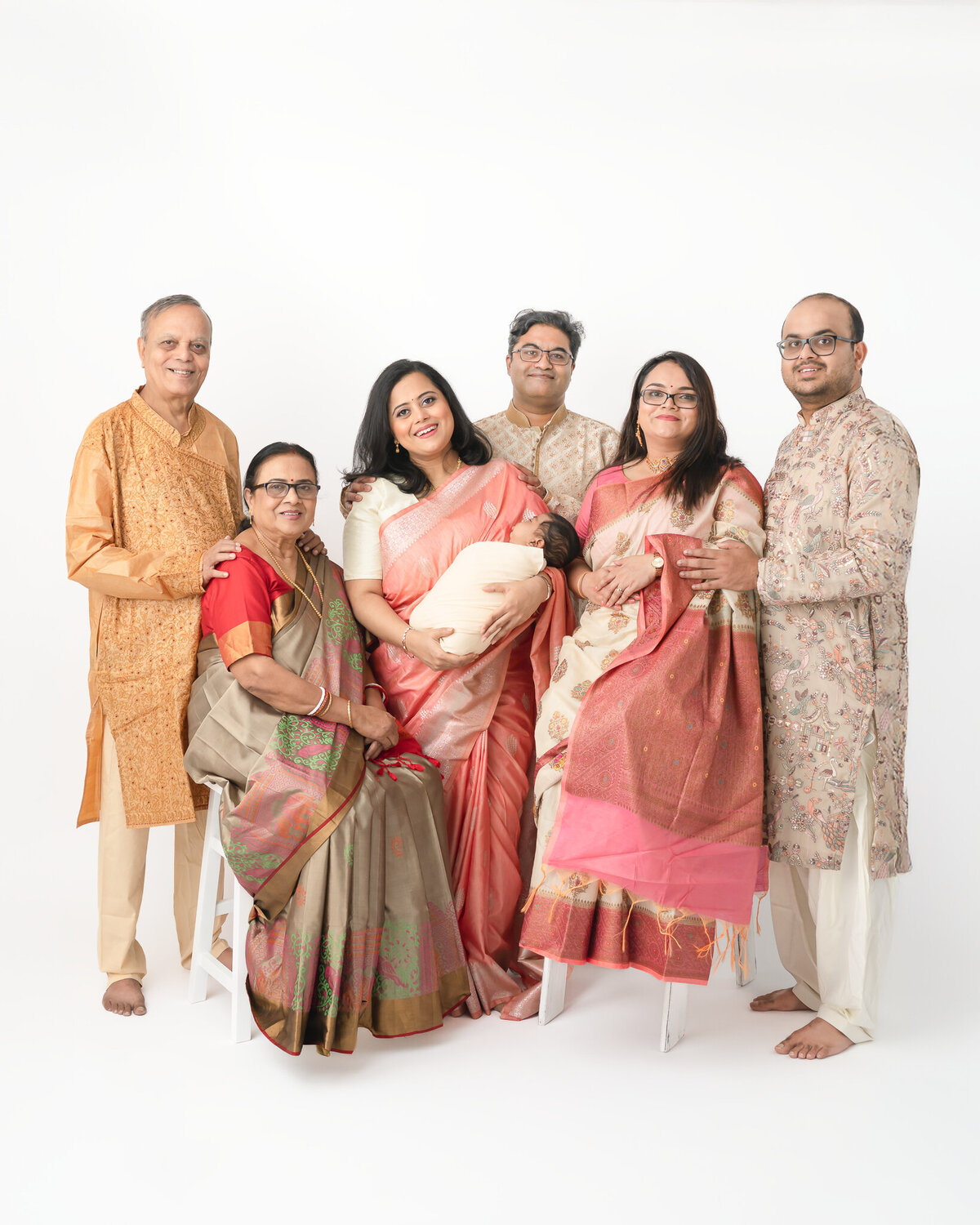 extended family studio portrait of family wearing traditional Indian clothing