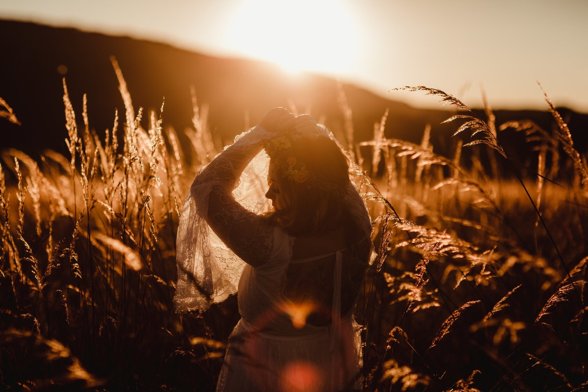 Couple embraced at sunset in field backlight by gorgeous light