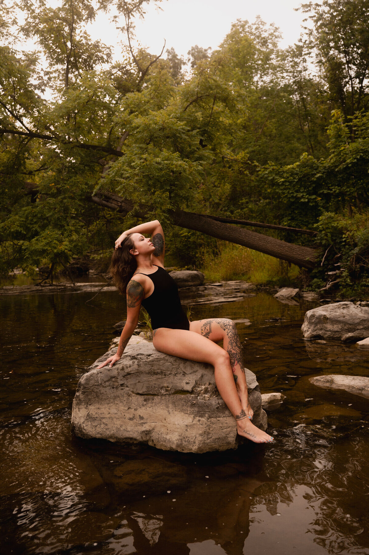 Taking in the sights and sounds of nature on top of a rock during a creekside outdoor boudoir session.