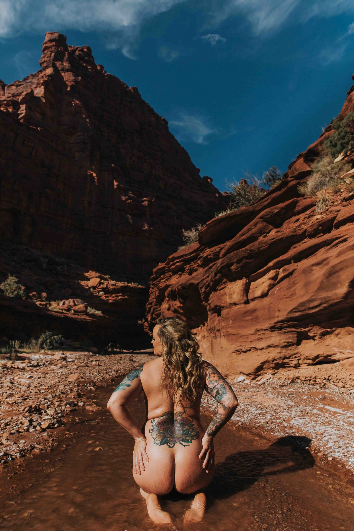 woman kneeling in a desert creek