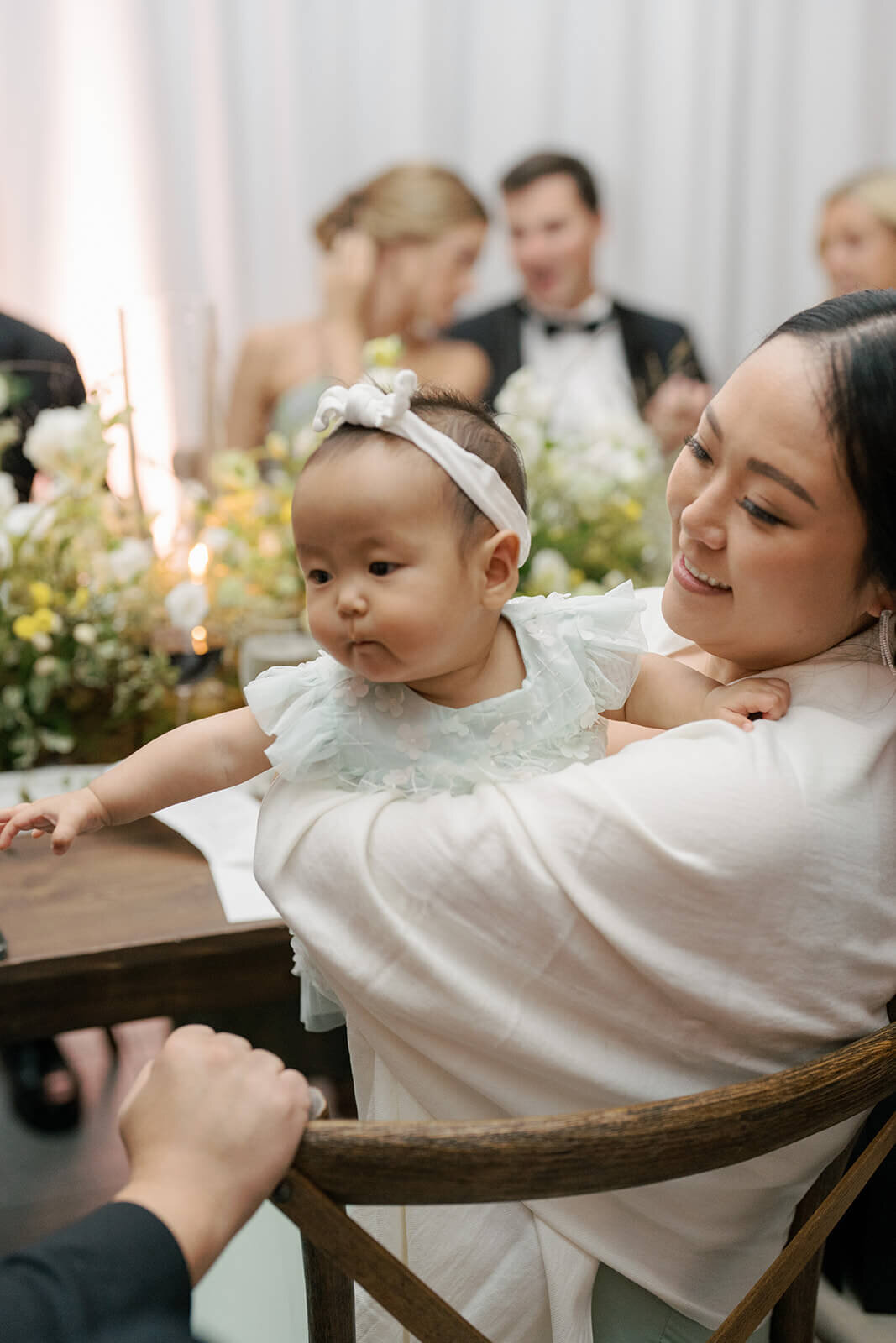 A guest and her baby enjoy the beautiful design of an Aspen Meadows Resort wedding reception.