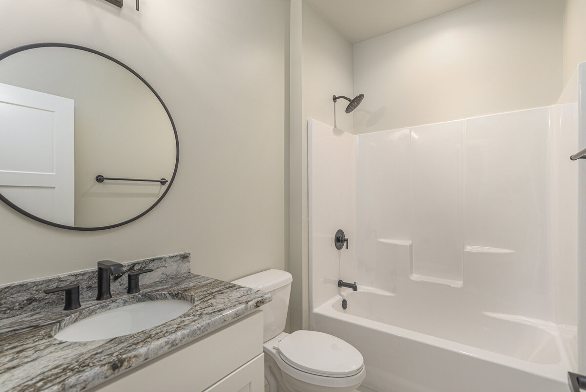 A white bathroom with a tub and shower