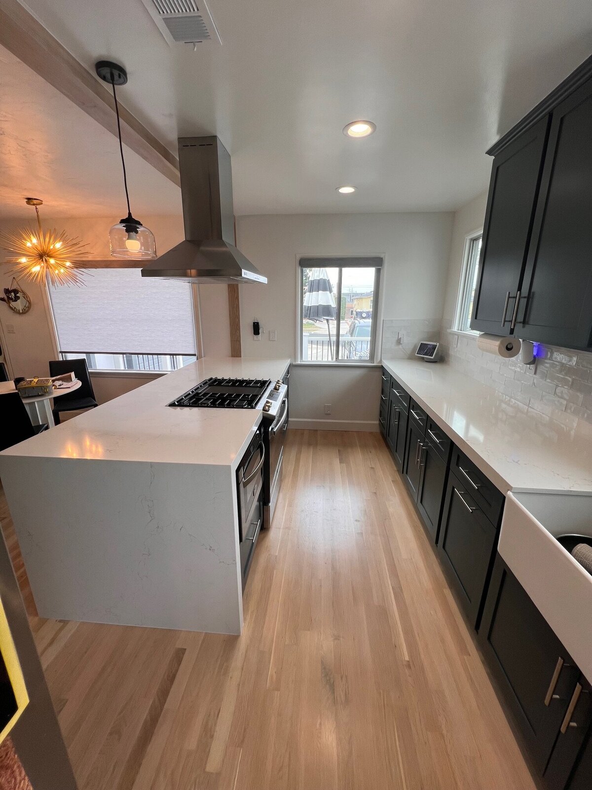 transitional-kitchen-white-countertops-black-cabinets-natural-light