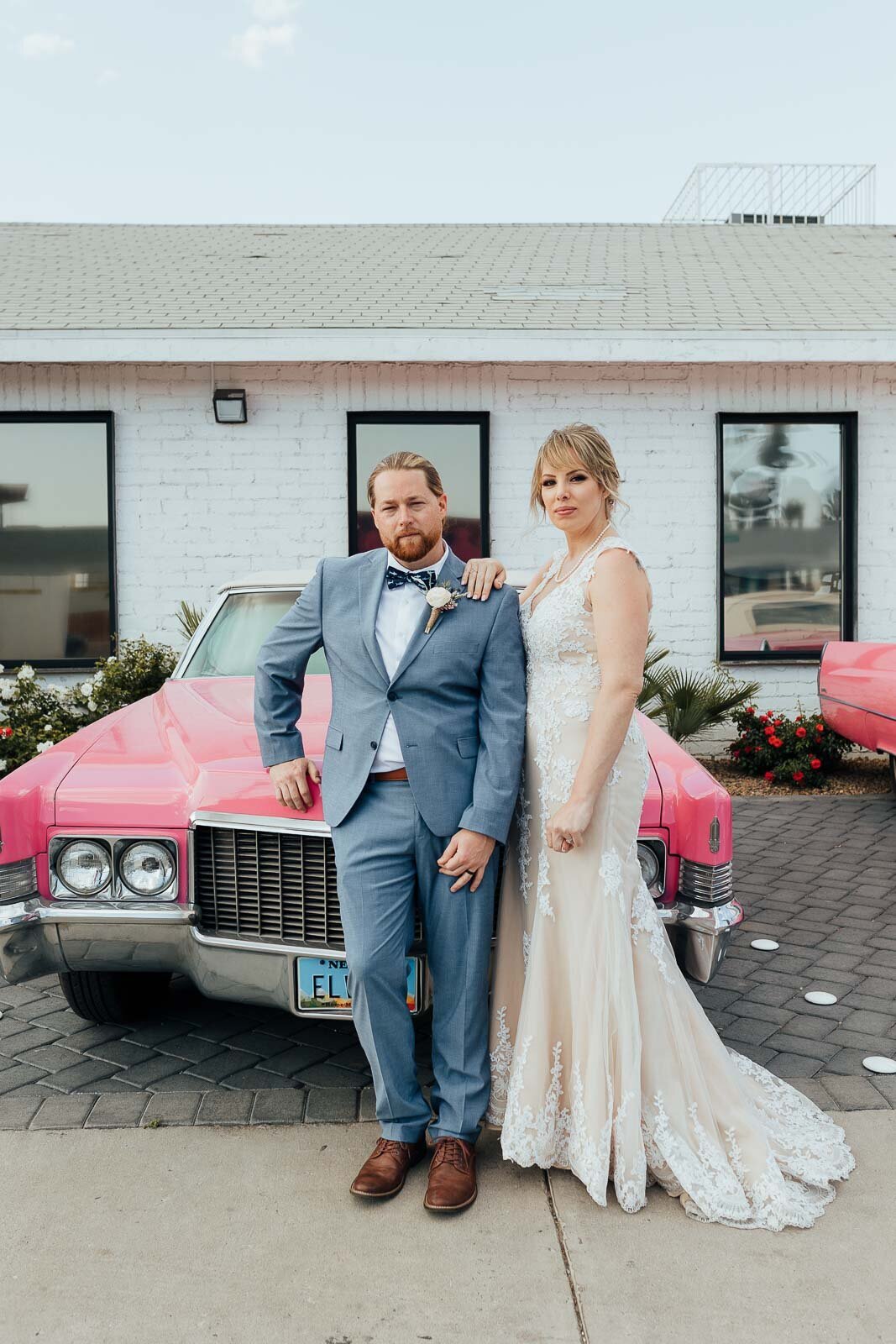 couple posing with pink Cadillac for Vegas elopement