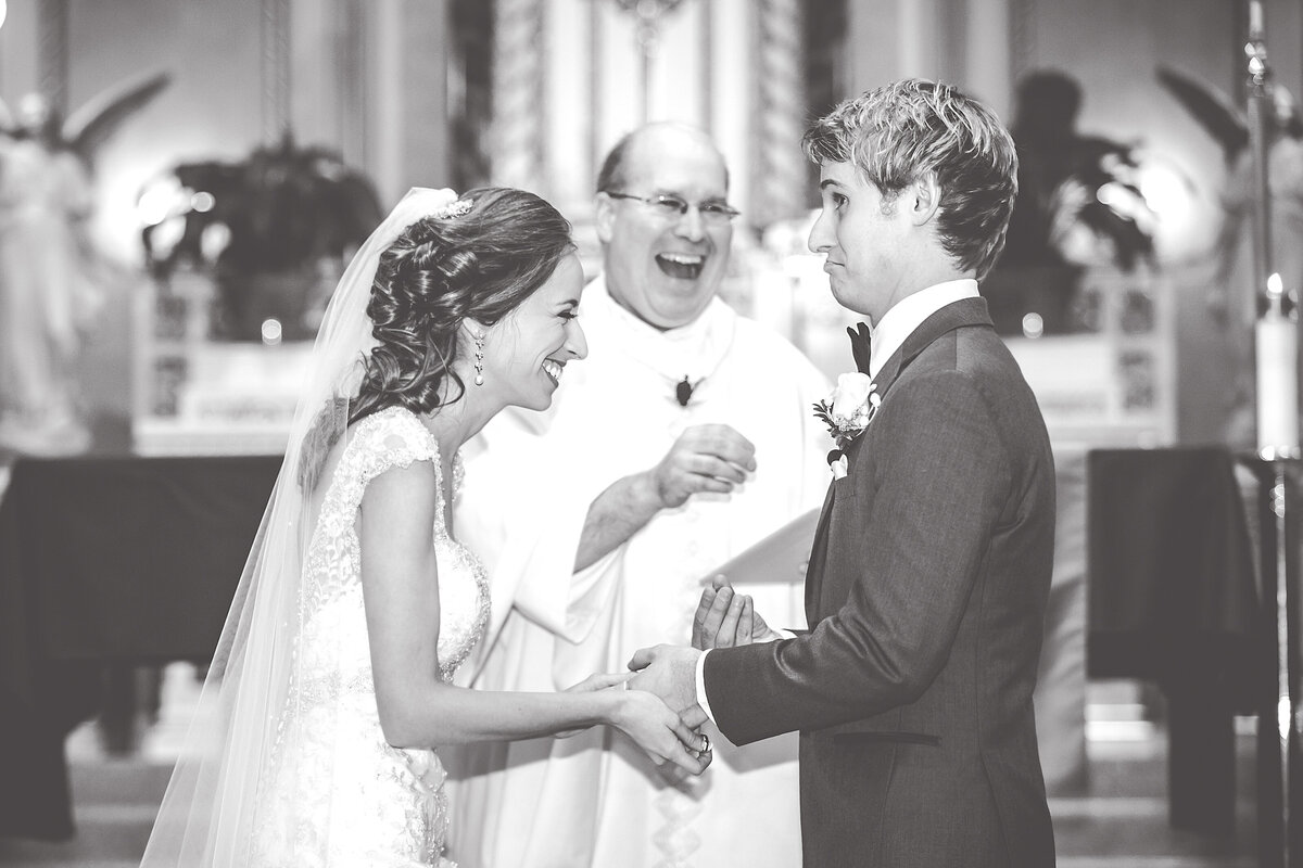 A bride laughs during a candid moment at her chicago wedding ceremony in a church.