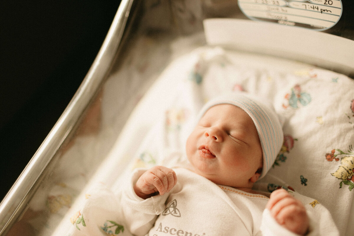 Mom and dad holding newborn in hospital room during Nashville Fresh 48 session.