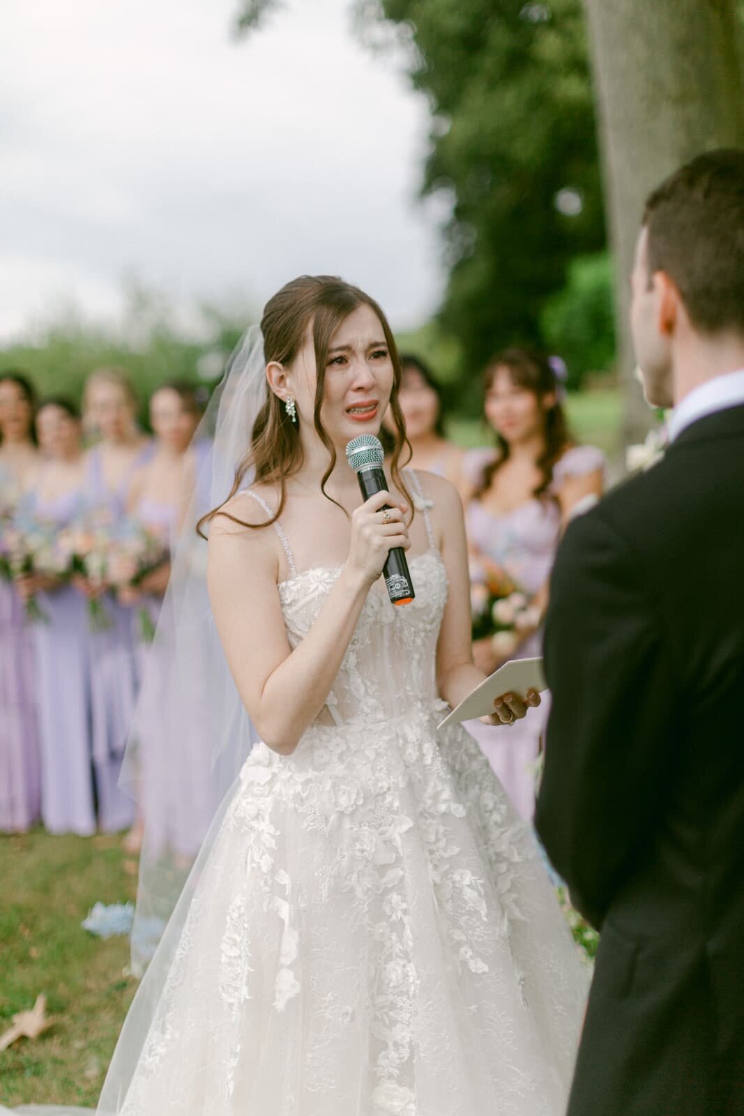 Emotional bride reading her vows during the ceremony, surrounded by bridesmaids, captured by Paris wedding photographer Thomas Raboteur
