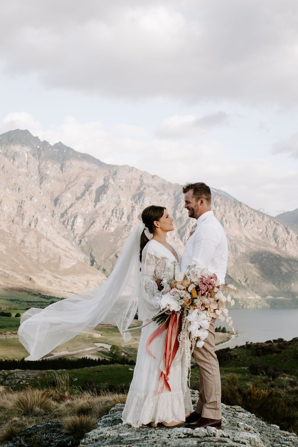 The Vase Floral Co - mountaintop wedding in Queenstown with bride holding large bouquet of flowers