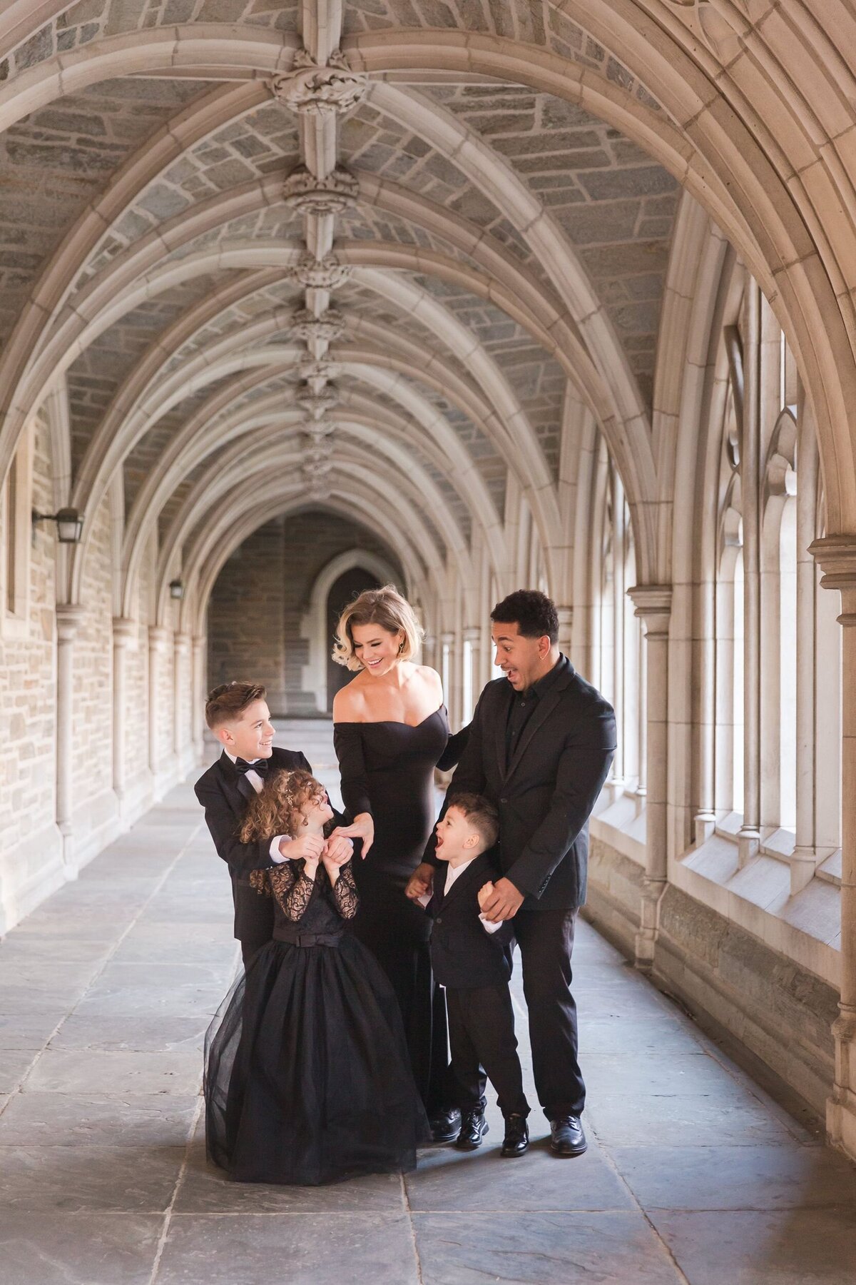 Family dressed formally in all black under church archway