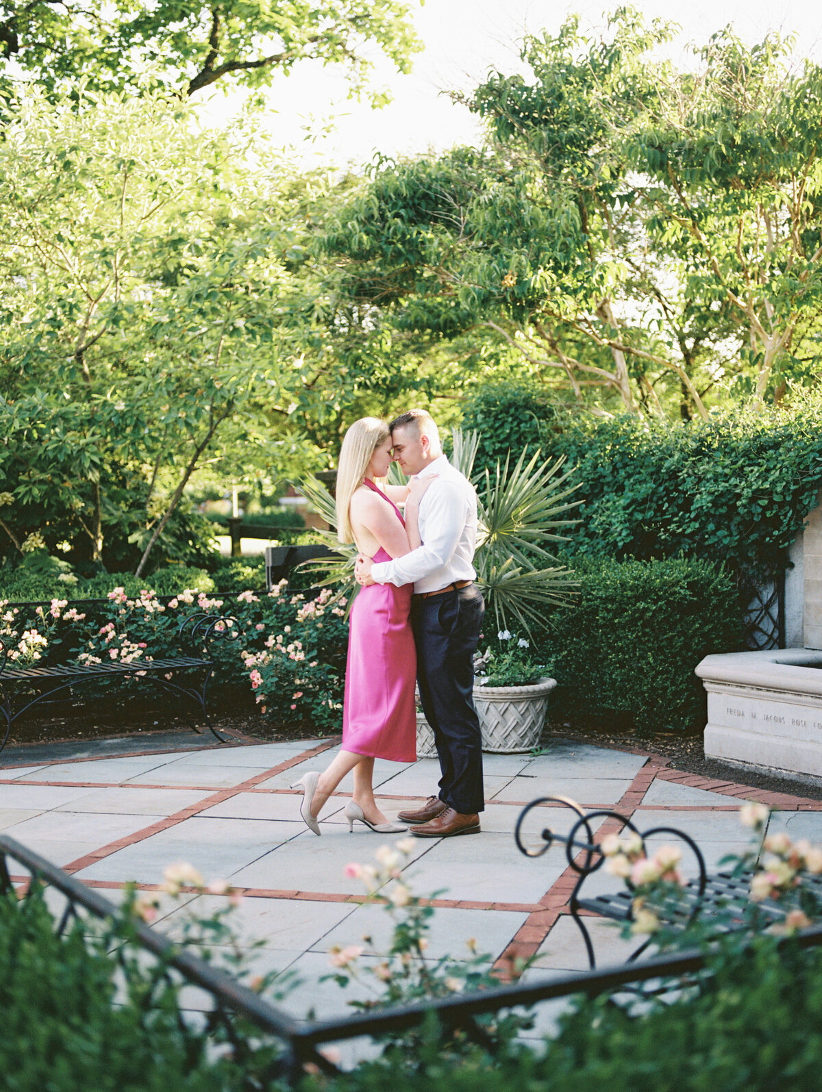 Couple touches foreheads near stone fountain in Columbus park shot by Philadelphia wedding photographer.