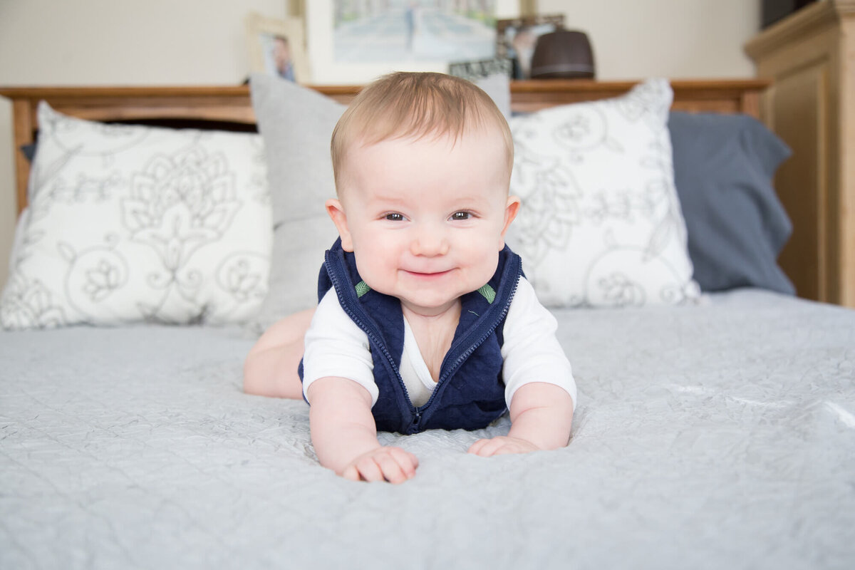 excited and happy baby boy on a bed