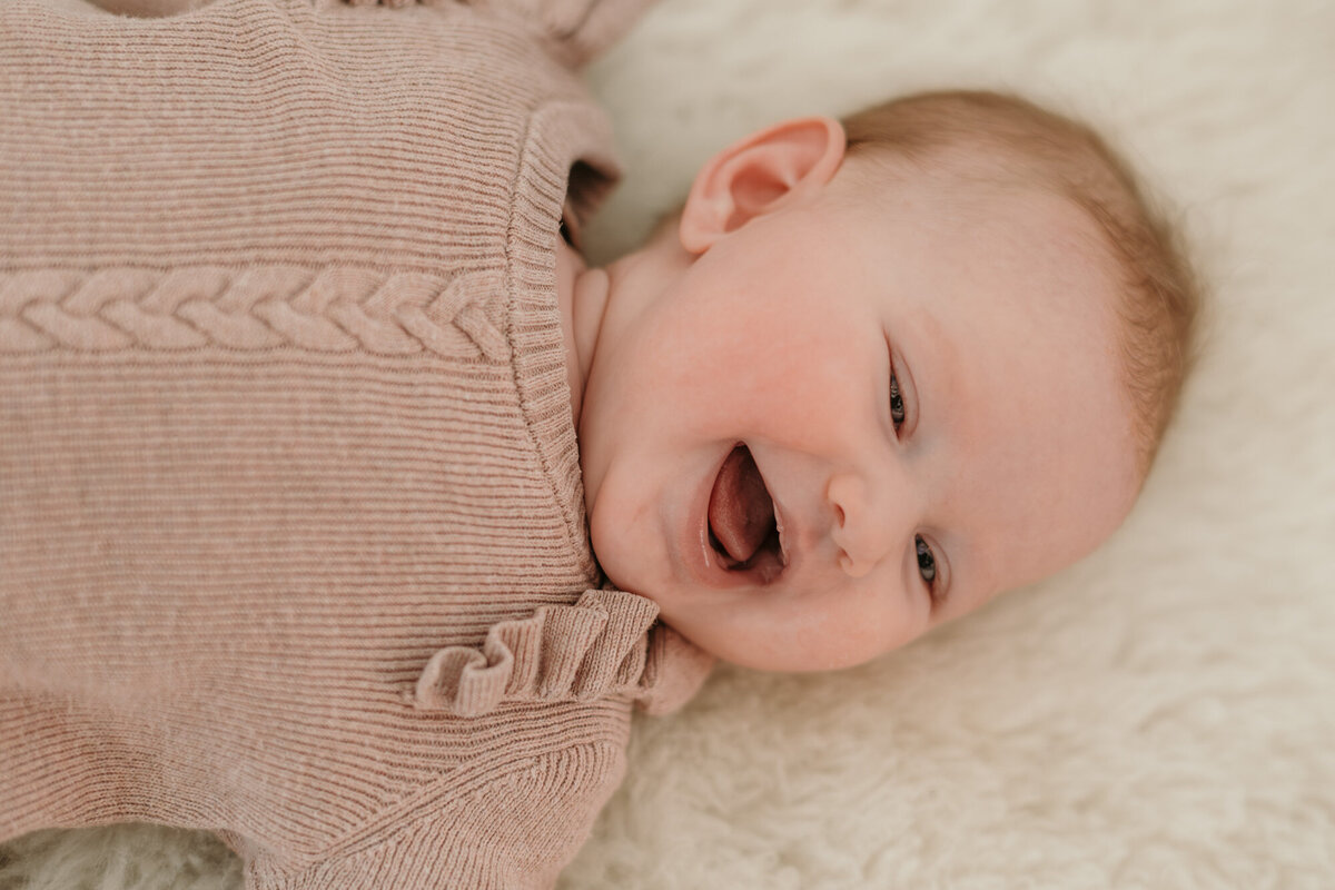 Babygirl laughing in this newborn photography.