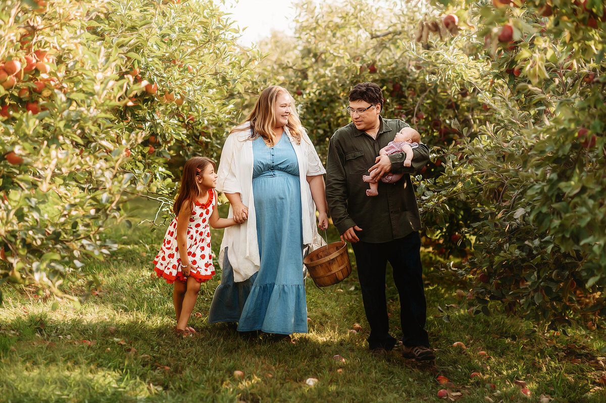 Family walks together in an apple orchard during Family Photos in Asheville.