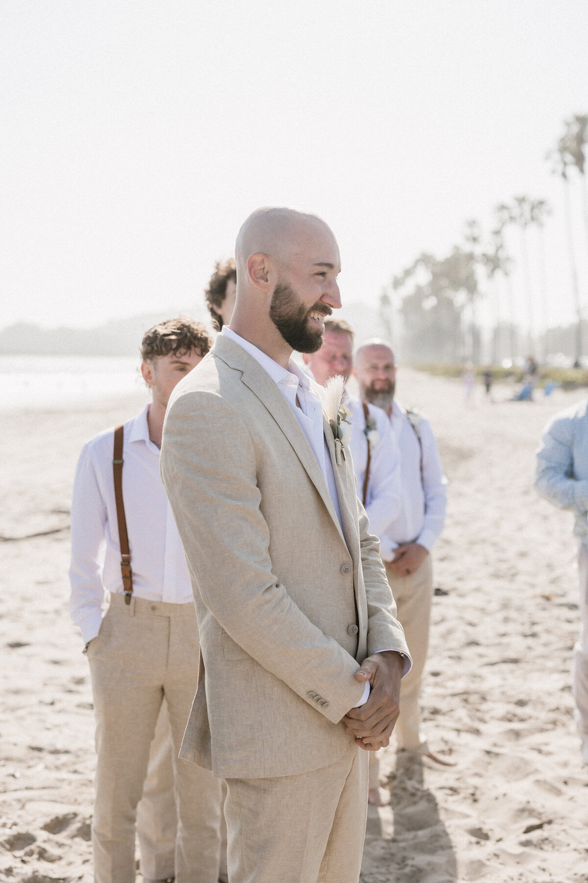 Groom watching bride walking down aisle on beach at Hilton Beachfront Resort Santa Barbara