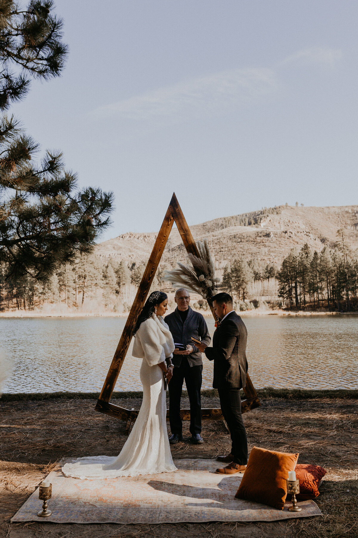 bride and groom having their elopement ceremony in front of a lake in New Mexico