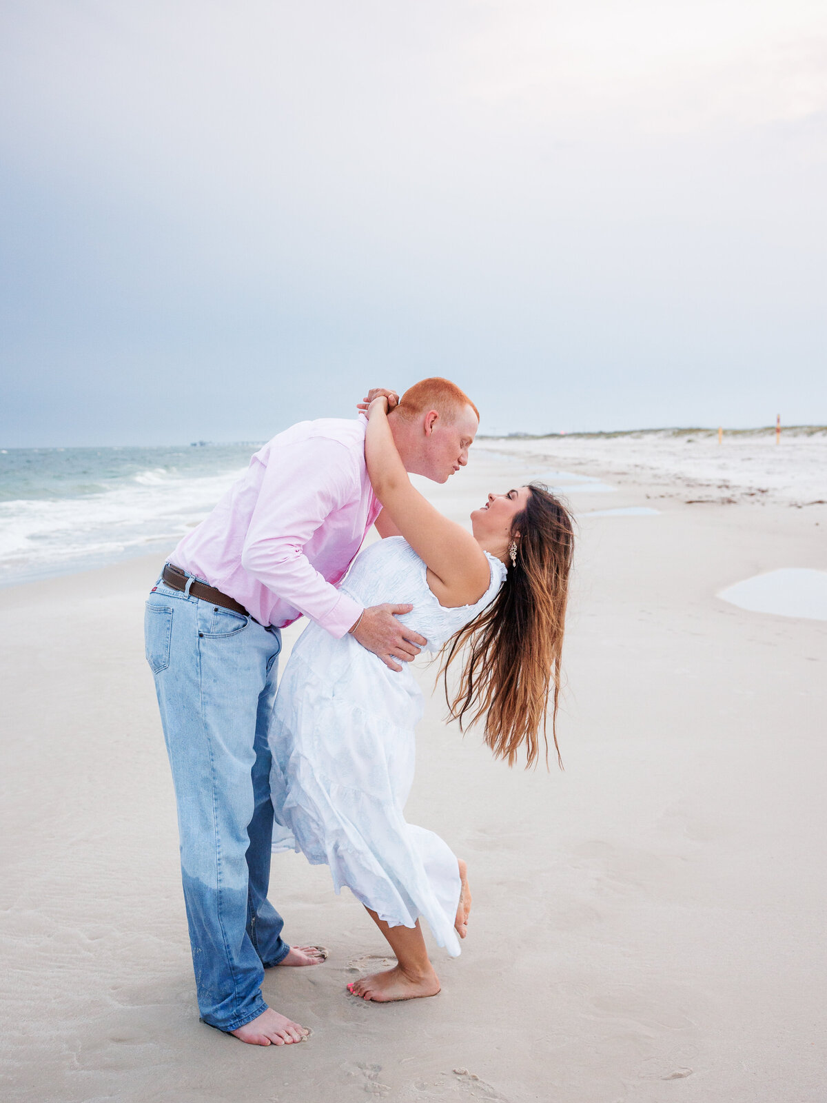 Couple on the shoreline playingfully kissing
